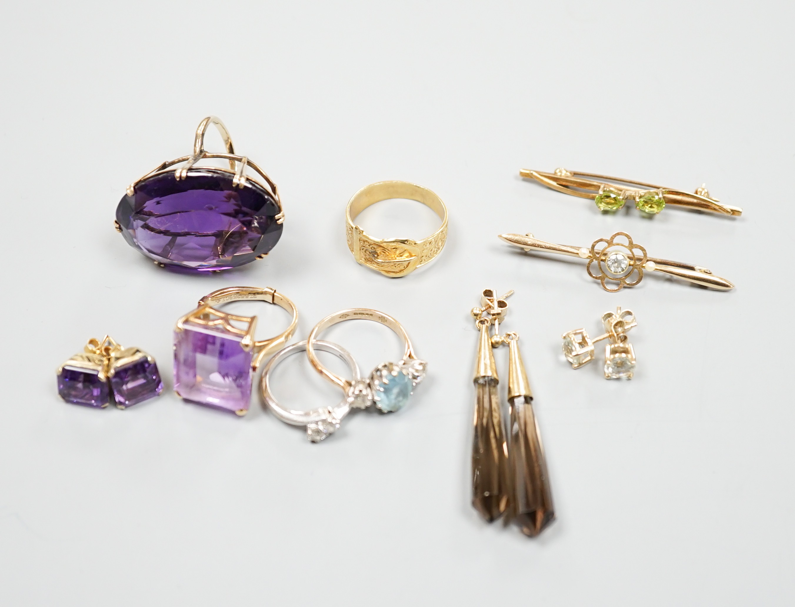 A large 9ct and oval cut amethyst dress ring, size L, three other rings including a 9ct gold buckle ring, an 18ct white gold and two stone crossover ring, two gem set bar brooches including 15ct and three assorted pairs
